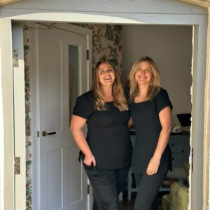 Two beauty therapists outside the front door of The Cottage